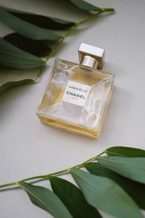 Gabrielle Essence Eau De Parfum bottle between two leafs